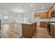 Bright kitchen with light wood cabinets, center island, stainless steel appliances, and an open floor plan at 2116 Chambers Rd, Brighton, CO 80601
