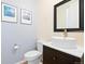 Cozy powder room with a pedestal sink, modern fixtures, and blue accent wall with framed art at 10554 Casper Pt, Parker, CO 80134