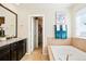 Bathroom featuring a large tub, vanity with sink, mirror and a walk-in closet at 10554 Casper Pt, Parker, CO 80134