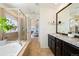 Bright primary bathroom featuring double vanity sinks, walk-in shower, and access to the main bedroom at 10554 Casper Pt, Parker, CO 80134