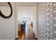 Inviting entryway featuring wood floors and modern wallpaper, leading to an open-concept kitchen and living area at 10554 Casper Pt, Parker, CO 80134