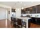 Bright kitchen with a granite island, dark cabinets, stainless steel appliances, and hardwood floors at 10554 Casper Pt, Parker, CO 80134