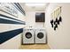 Functional laundry room with modern washer and dryer units, storage cabinets, and stylish decor at 10554 Casper Pt, Parker, CO 80134