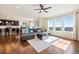 Bright and open living area with ample sunlight, hardwood floors, and modern, comfortable gray sectional sofa at 10554 Casper Pt, Parker, CO 80134