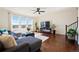 Spacious living room with hardwood floors, large windows, modern ceiling fan, and comfortable seating area at 10554 Casper Pt, Parker, CO 80134
