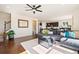 Well-lit living room with hardwood floors, gray couch, and an open layout connecting to the kitchen and dining area at 10554 Casper Pt, Parker, CO 80134