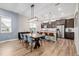 Elegant dining area with a large wooden table, stylish chairs, and a view of the modern kitchen at 6776 Navajo Way, Denver, CO 80221