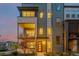 Contemporary townhouse with large windows and a red front door, set against a colorful sky at 6776 Navajo Way, Denver, CO 80221