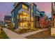 Modern home exterior featuring a balcony and lush landscaping with flowering trees at 6776 Navajo Way, Denver, CO 80221
