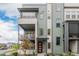 Three-story townhome boasts a charming balcony, colorful siding, and a welcoming red front door at 6776 Navajo Way, Denver, CO 80221