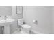 Clean half-bathroom with a white sink, toilet, light gray walls, and modern fixtures at 6776 Navajo Way, Denver, CO 80221