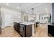 Open kitchen with large island, stainless steel appliances, and hardwood floors leading to a dining and living area at 6776 Navajo Way, Denver, CO 80221
