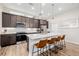 Modern kitchen with stainless steel appliances, center island seating, and stylish pendant lighting at 6776 Navajo Way, Denver, CO 80221
