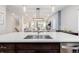 Bright kitchen island with a modern sink and faucet, accompanied by stylish pendant lighting and an open-concept design at 6776 Navajo Way, Denver, CO 80221