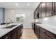 Modern kitchen featuring dark wood cabinets, white countertops, stainless steel appliances, and a large window at 6776 Navajo Way, Denver, CO 80221