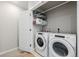 Functional laundry room with modern appliances, storage shelving, and efficient layout at 6776 Navajo Way, Denver, CO 80221