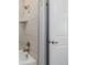 Close up of a tiled shower and tub featuring modern fixtures and clean design at 6776 Navajo Way, Denver, CO 80221