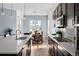 Open kitchen with modern appliances, quartz countertops, and dining area with elegant chandelier at 15750 Willow Way, Brighton, CO 80602