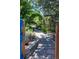 Secluded backyard featuring a brick path, blue fence and verdant landscaping at 901 S Leyden St, Denver, CO 80224