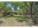 Spacious backyard with lush greenery, mature trees and shaded seating area at 901 S Leyden St, Denver, CO 80224