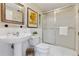 Bright bathroom features a pedestal sink, toilet, glass enclosed shower, and decorative mirror at 901 S Leyden St, Denver, CO 80224