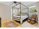 Bright bedroom with hardwood floors, four-poster bed, and natural light from multiple windows at 901 S Leyden St, Denver, CO 80224