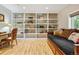 Bright bonus room features built-in shelving, hardwood floors, and a daybed with decorative pillows at 901 S Leyden St, Denver, CO 80224