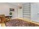 Bonus room featuring hardwood floors, built-in shelving, and comfortable rocking chair at 901 S Leyden St, Denver, CO 80224