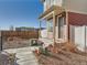 Side view of a two-story home with neutral siding, a front porch, and gravel landscaping, complemented by a wooden fence at 4987 N Walden Way, Denver, CO 80249