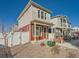 Charming two-story home with neutral siding and a cozy front porch, complemented by gravel landscaping and a white picket fence at 4987 N Walden Way, Denver, CO 80249