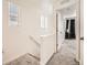 The hallway is bright with natural light and features neutral paint and grey carpet at 4987 N Walden Way, Denver, CO 80249