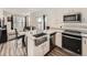 Modern kitchen featuring stainless steel appliances, white cabinets, and an island with a sink and seating at 4987 N Walden Way, Denver, CO 80249