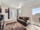 Cozy living room featuring a leather sofa, wood floors, and a sliding door with natural light at 4987 N Walden Way, Denver, CO 80249