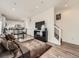 Open-concept living space with hardwood floors, a comfortable sofa, and a view of the modern kitchen and staircase at 4987 N Walden Way, Denver, CO 80249