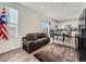 Bright living room featuring a leather sofa, wood floors, and a view into the modern kitchen at 4987 N Walden Way, Denver, CO 80249