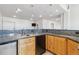 Cozy bar area features a mini-fridge, granite countertops, light wood cabinets, and modern pendant lights at 1967 Haystack Rd, Castle Rock, CO 80104