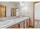 Neutral bathroom with a double-sink vanity, natural wood trim, a large mirror and ample storage at 1967 Haystack Rd, Castle Rock, CO 80104