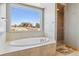 Bright bathroom with large soaking tub, and glass enclosed shower with a picturesque view from the large window at 1967 Haystack Rd, Castle Rock, CO 80104