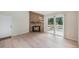 Spacious living room with hardwood floors, stone fireplace, and access to outdoor deck at 10251 W 44Th Ave # 3-204, Wheat Ridge, CO 80033