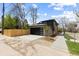 Modern home with a dark garage door, well-manicured landscaping, and a paved driveway and sidewalk at 1100 S Elizabeth St, Denver, CO 80210