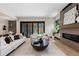 Open living room with fireplace, sleek furniture, hardwood flooring, and natural light from sliding doors at 1100 S Elizabeth St, Denver, CO 80210