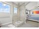 Modern walk-in shower with glass door and tile surround, leading to bedroom with ceiling fan at 5211 E 116Th Ave, Thornton, CO 80233