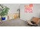 Hallway decorated with a pink flower painting, plant, and chair next to the wooden stair railing at 5211 E 116Th Ave, Thornton, CO 80233