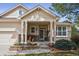 Inviting front porch with stately columns, stone accents, and decorative flower beds, offering great curb appeal at 1844 S Jay Way, Lakewood, CO 80232
