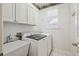 Convenient laundry room features utility sink, washer, dryer, and ample storage at 1844 S Jay Way, Lakewood, CO 80232