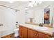 Bathroom featuring a shower and tub, mirror, and vanity, and adjacent access to the kitchen at 8778 S Kipling Way # 304, Littleton, CO 80127