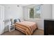 Well-lit bedroom featuring a bed, side table with a lamp, a window, and a closet at 8778 S Kipling Way # 304, Littleton, CO 80127
