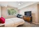 Bright bedroom featuring a window view, a bed, and a dresser with built-in drawers at 8778 S Kipling Way # 304, Littleton, CO 80127