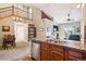 Open-concept view from kitchen with stainless appliances into the carpeted living room with fireplace at 8778 S Kipling Way # 304, Littleton, CO 80127