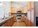 Charming kitchen showcasing stainless steel appliances, granite countertops and wood cabinets at 8778 S Kipling Way # 304, Littleton, CO 80127